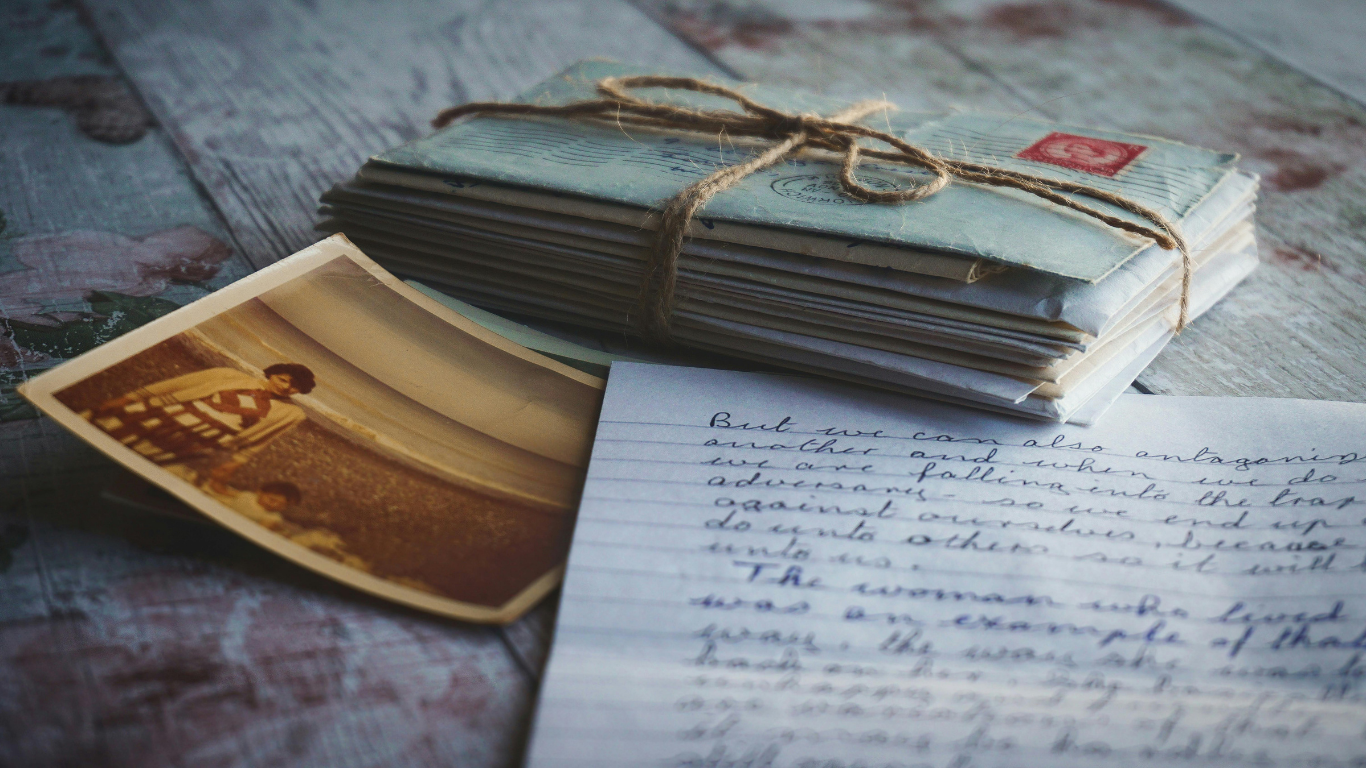 Archives Material Old photograph, open handwritten letter, and a bundle of envelopes tied with string, displayed together